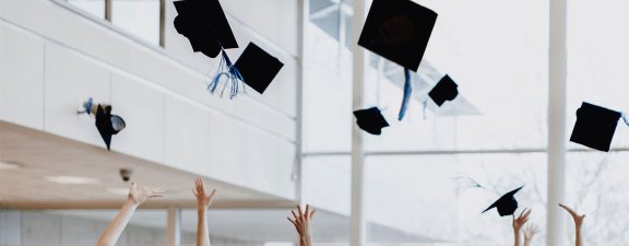 Graduation hats being tossed up into the air