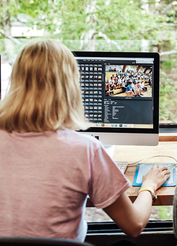 Students looking through images on a computer.
